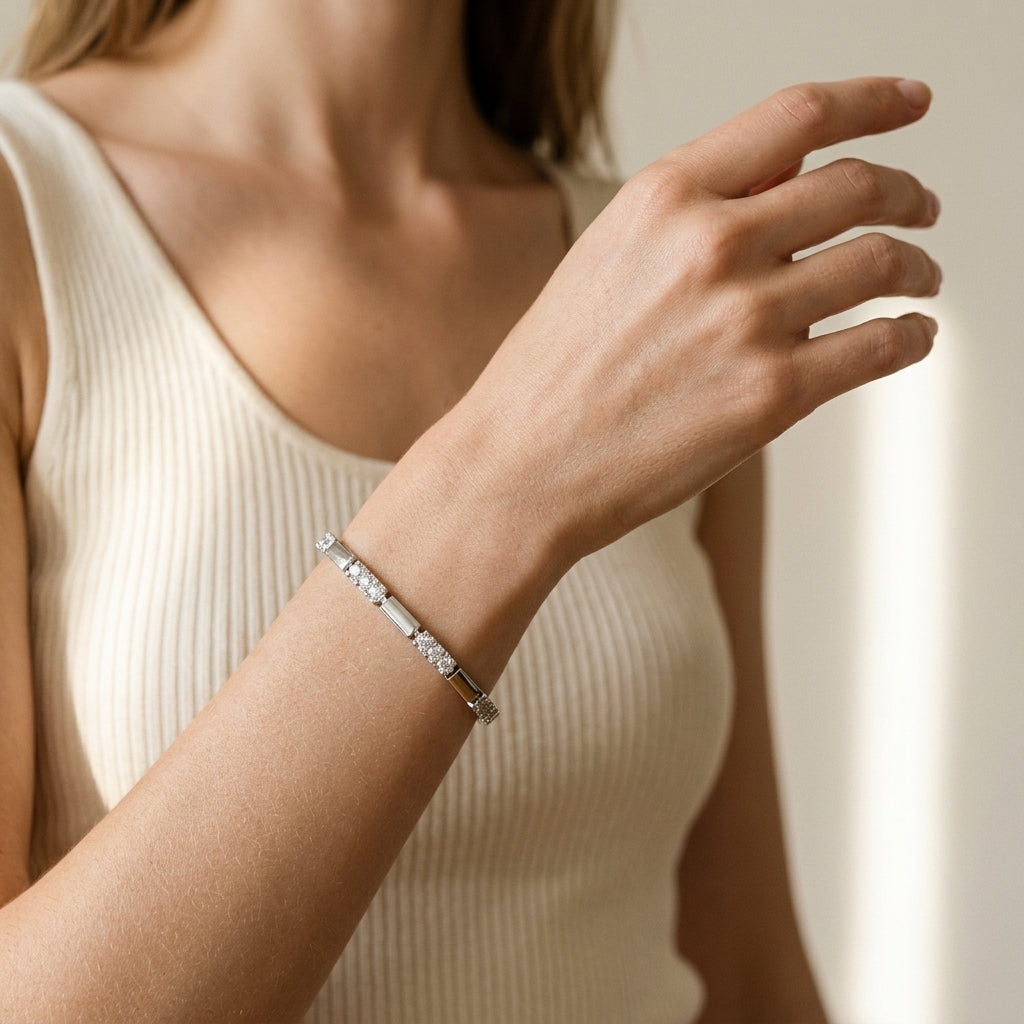 Mulher de regata creme usando a pulseira de elos lisos e trechos cravejados, banhada a ródio