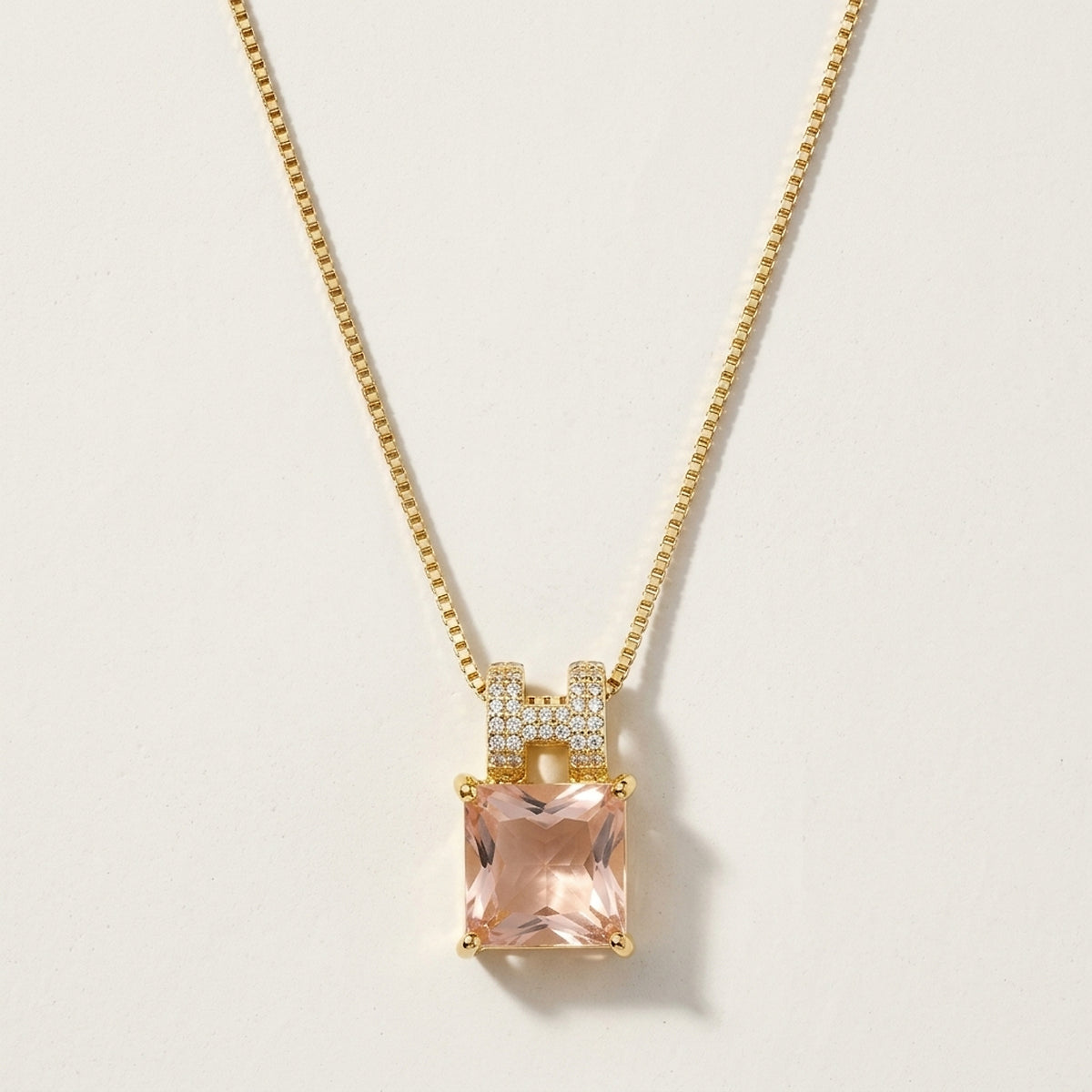 Gargantilha com pingente de pedra rosa cravejado de zircônias, banhada a ouro