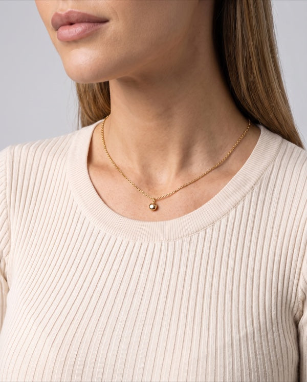 Colo de mulher com colar fino de corrente banhado a ouro, luz neutra